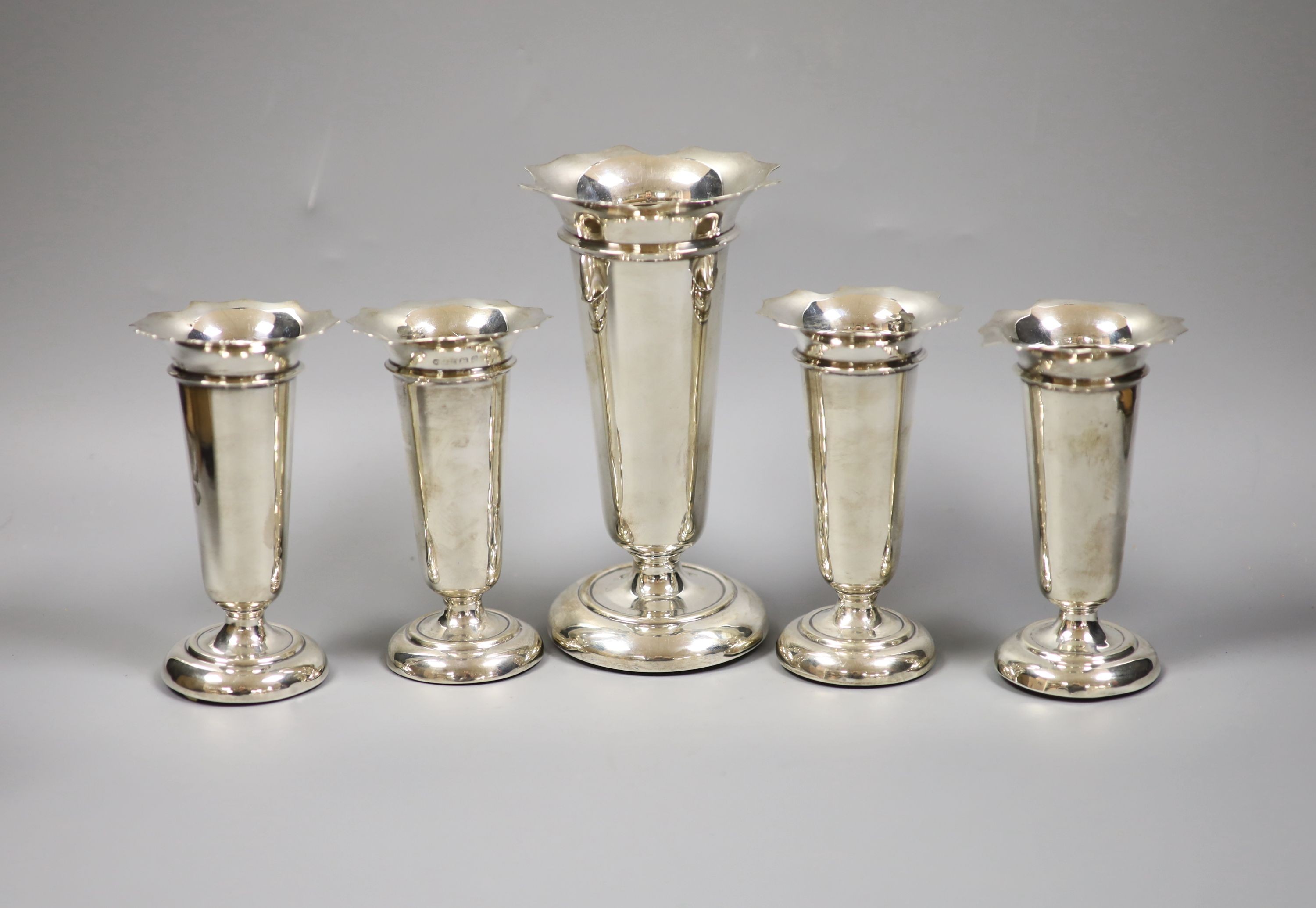 A set of four George V silver posy vases, 11.5cm high, together with a single tall example, 16cm high, Birmingham, 1915 by Deakin & Francis Ltd (weighted) (5).